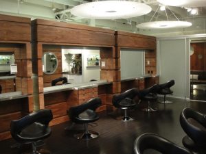 Wooden barbershop with large wooden cabinets and mirrors.