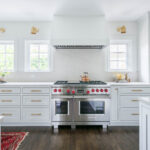 White kitchen cabinets with silver stove.