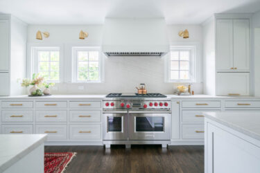 White kitchen cabinets with silver stove.